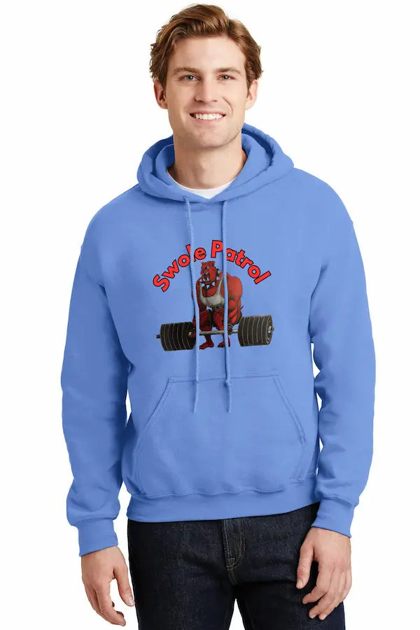 Man wearing SWOLE PATROL Hoodie flexing in gym with dumbbells.