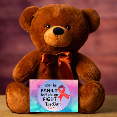 A plush teddy bear with a printed message card that reads 'We The Family Will Always Fight Together', indicating support for cancer research.