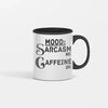 White ceramic coffee mug reading “Mood: Sarcasm 80% Caffeine 20%” in bold black lettering, sitting on a wooden desk beside a laptop and notebook.