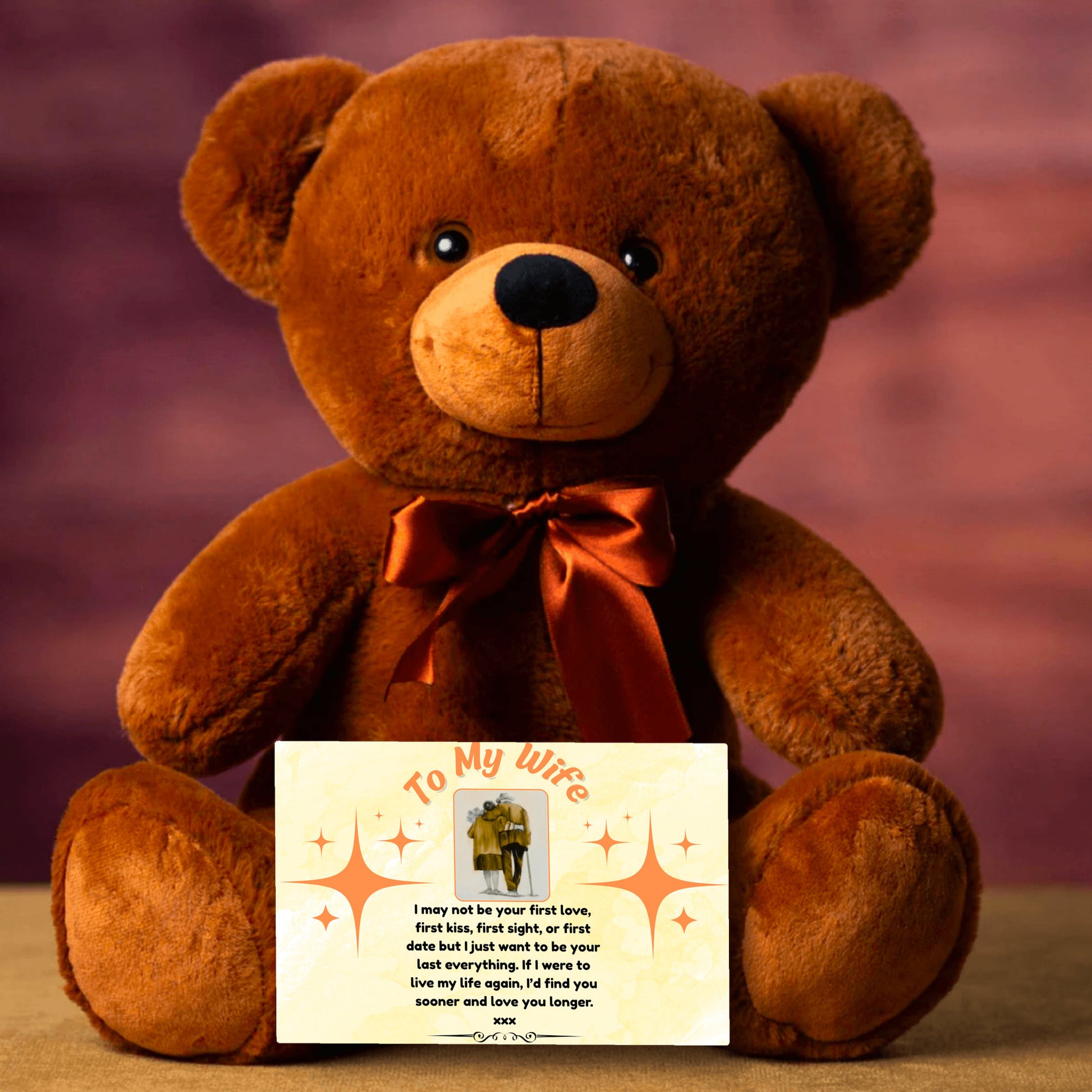 A soft plush teddy bear holding a heart-shaped tag and a printed card titled “To My Wife – Never Forget.” Set on a white gift box surrounded by roses and ribbon.