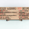 “All Out Comedy Plaque TRIGGER WARNING AOC Show political humor wall decor hanging on a wooden background”