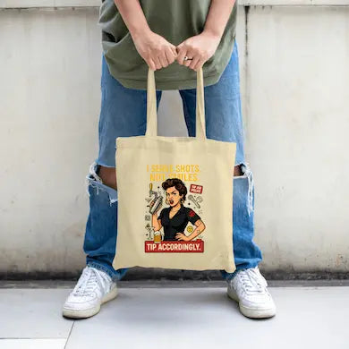 Bartender-inspired tote bag with bold text “I Serve Shots Not Smiles” printed in striking black font.