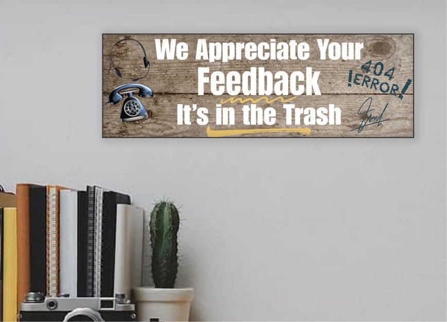 A rectangular wooden plaque featuring the sarcastic phrase "We Appreciate Your Feedback – It’s in the Trash" in bold white and red text on a dark vintage background with ornamental border details.