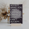 A wood-finish plaque with bold black text that reads “Accept What You Can’t Change” in capital letters, set in a clean and modern font.