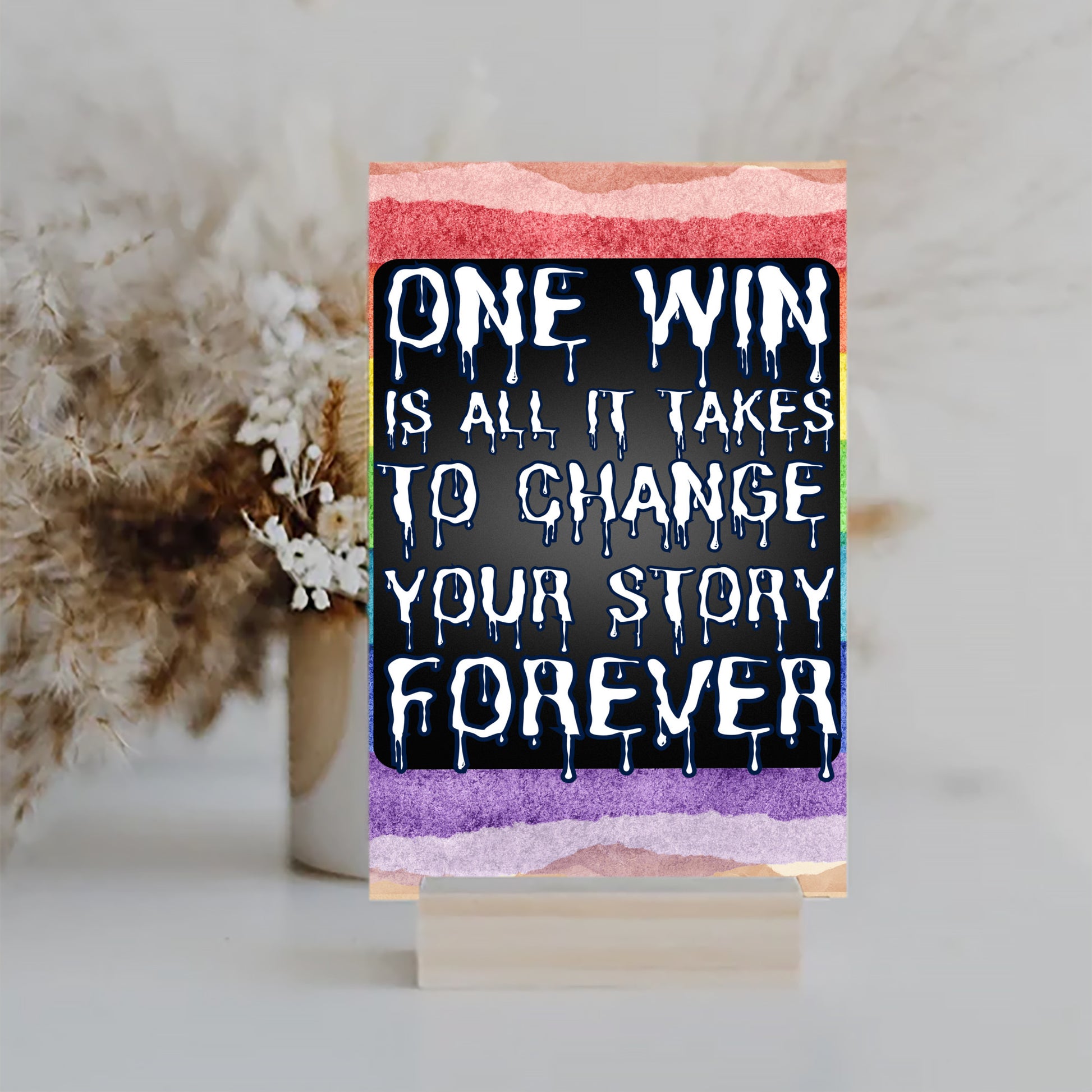 "Motivational wall plaque that reads ‘One Win Is All It Takes to Change Your Story Forever’ displayed above a desk workspace"