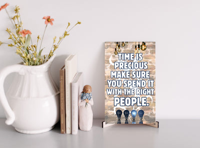 Emotional quote plaque reading “Time Is Precious” in soft script on neutral wood background, styled in a cozy living room setting with natural light.