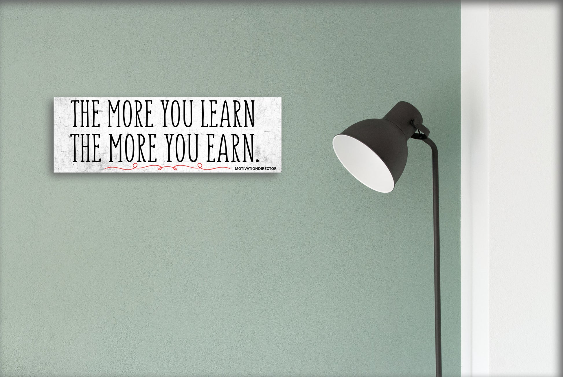 A modern motivational plaque with bold block text that reads “The More You Learn – The More You Earn” on a clean woodgrain background.