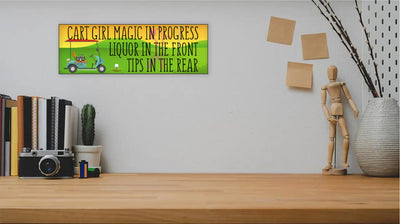 Wooden plaque with bold pink lettering reading “Cart Girl Magic In Progress” featuring cartoon-style golf cart, drink tray, and dollar signs—displayed outdoors.