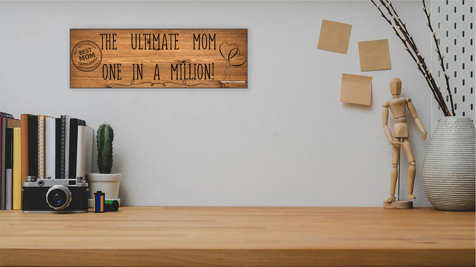 Wooden plaque reading “The Ultimate Mom” in bold script with floral accents and comic-style doodles, perfect for gifting or home décor.