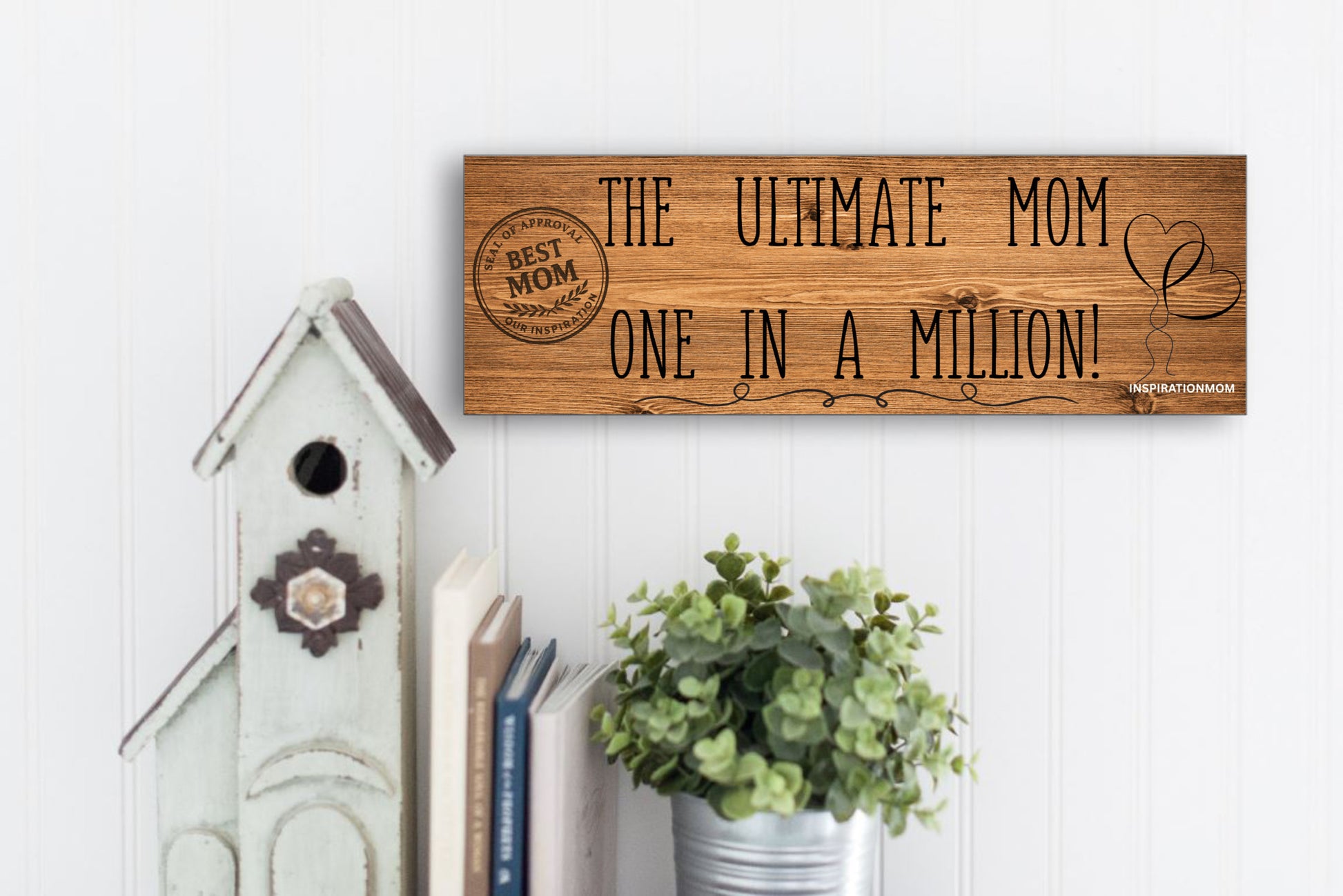Wooden plaque reading “The Ultimate Mom” in bold script with floral accents and comic-style doodles, perfect for gifting or home décor.