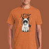 Person wearing an orange t-shirt with a cat graphic and 'NOPE' text on a brown background