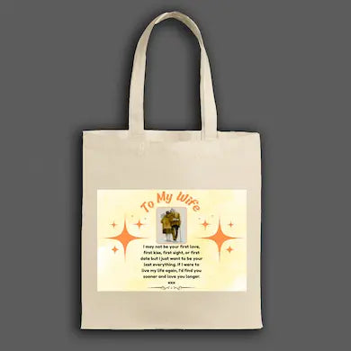 Person holding a beige tote bag with a Romantic first kiss quote tote bag gift for wife