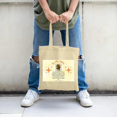 Person holding a beige tote bag with a Romantic first kiss quote tote bag gift for wife