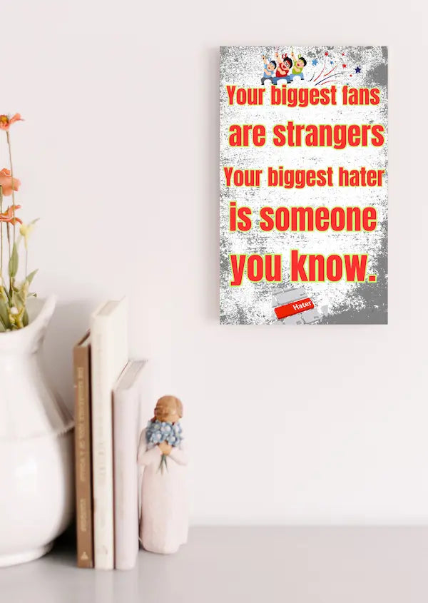 Wooden plaque with bold text: “Your biggest fans are strangers. Your biggest hater is someone you know,” styled with comic-style humor.