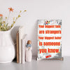 Wooden plaque with bold text: “Your biggest fans are strangers. Your biggest hater is someone you know,” styled with comic-style humor.