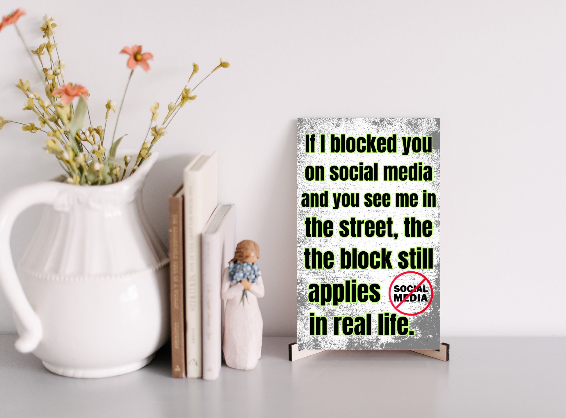 Wooden plaque with bold comic-style text: “If I blocked you on social media, you probably deserved it” displayed in sarcastic font.