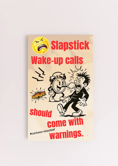 “Funny wall plaque reading 'Slapstick Wake Up Calls Should Come with Warnings' displayed on a kitchen wall near a coffee mug”