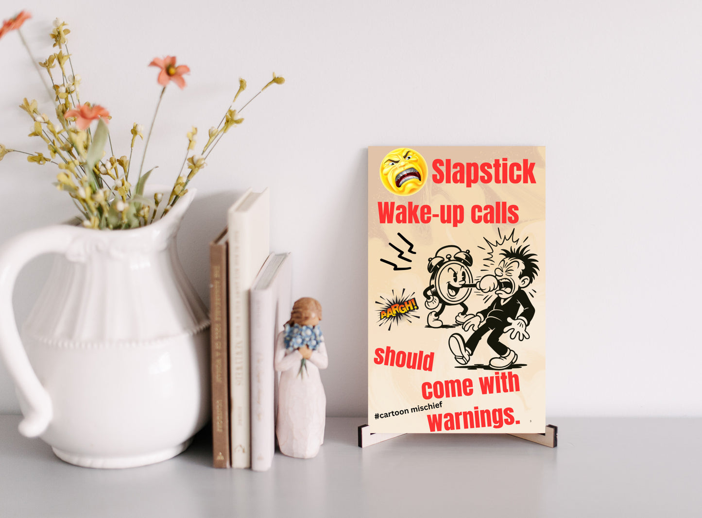 “Funny wall plaque reading 'Slapstick Wake Up Calls Should Come with Warnings' displayed on a kitchen wall near a coffee mug”