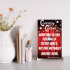 “Comedy wall plaque reading ‘Adulting is like folding a fitted sheet’ displayed in a cozy laundry room next to messy clothes”