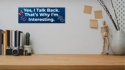 Funny humorous wall plaque with the phrase “YES, I TALK BACK – THAT’S WHY I’M INTERESTING” in bold lettering.