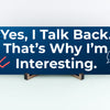 Funny humorous wall plaque with the phrase “YES, I TALK BACK – THAT’S WHY I’M INTERESTING” in bold lettering.