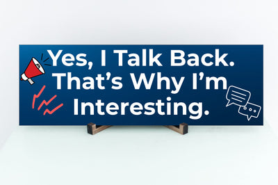 Funny humorous wall plaque with the phrase “YES, I TALK BACK – THAT’S WHY I’M INTERESTING” in bold lettering.