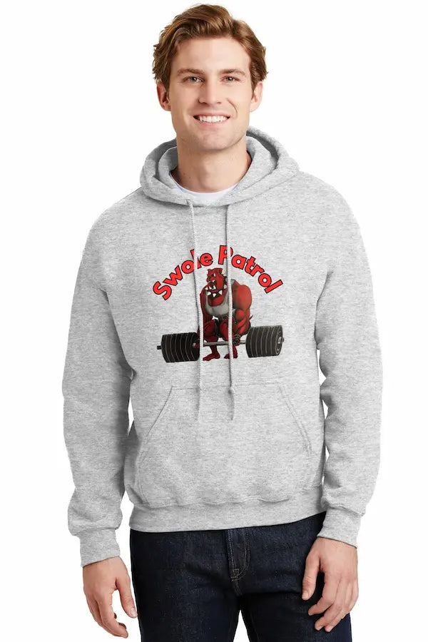 Man wearing SWOLE PATROL Hoodie flexing in gym with dumbbells.