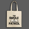 Swole Patrol Tote in matte black, roomy design with gym and lifestyle essentials, carried by athlete in urban gym setting