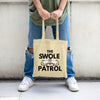 Swole Patrol Tote in matte black, roomy design with gym and lifestyle essentials, carried by athlete in urban gym setting