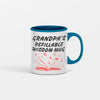 White ceramic coffee mug with bold black text that reads “Grandpa Refillable Wisdom Mug,” sitting on a rustic wooden table beside reading glasses.
