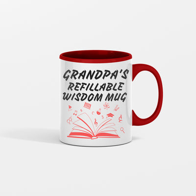 White ceramic coffee mug with bold black text that reads “Grandpa Refillable Wisdom Mug,” sitting on a rustic wooden table beside reading glasses.
