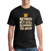 Grandma and grandpa wearing "Retired But Still Running the Show" funny retirement T-shirt, smiling with confidence.