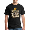 Grandma and grandpa wearing "Retired But Still Running the Show" funny retirement T-shirt, smiling with confidence.
