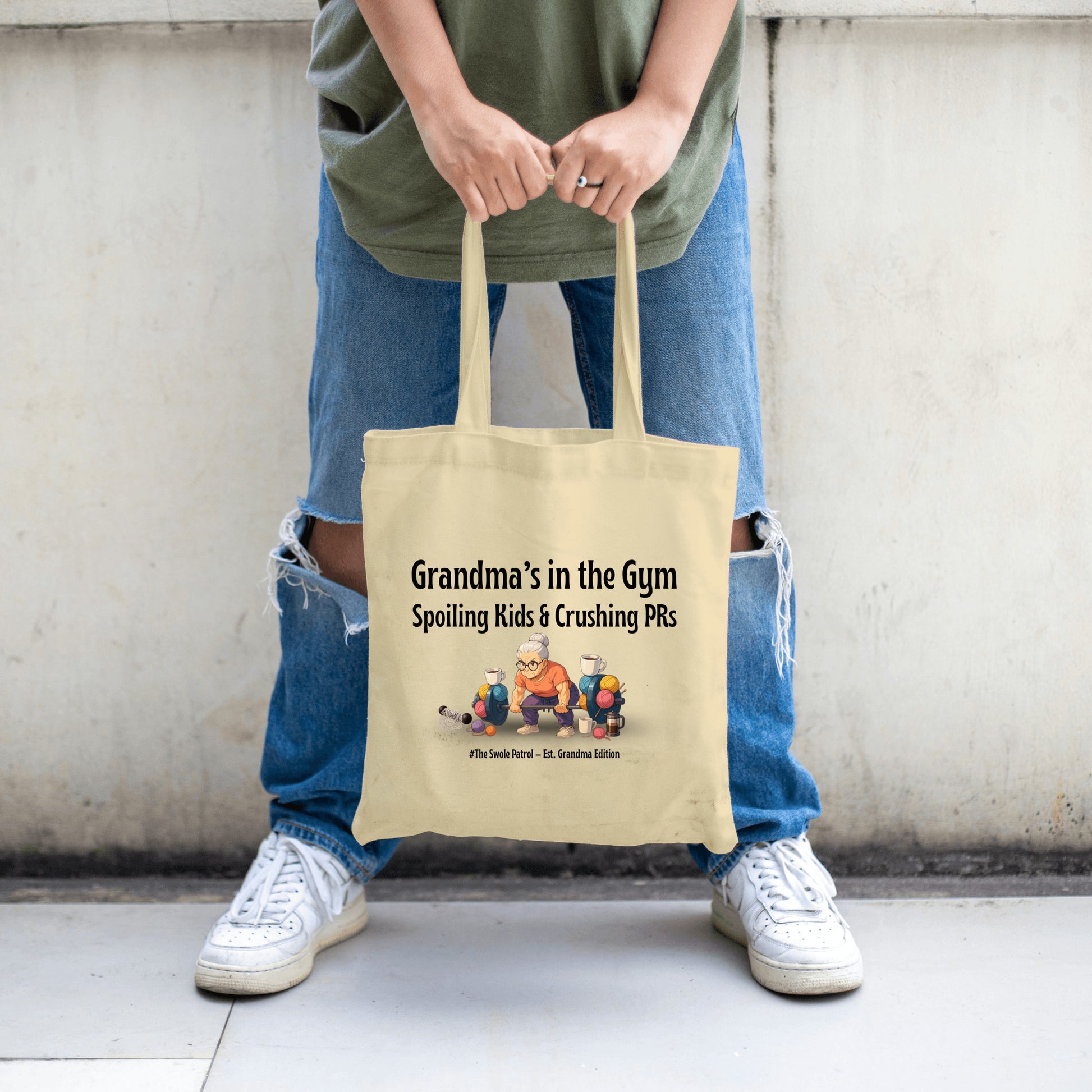 Anime-style illustration of a tough grandmother carrying the “Grandma’s in the Gym Tote Bag” into a gym filled with weights.