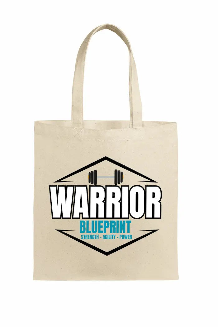 Cinematic shot of the Warrior Blueprint Tote Bag resting beside gym gear and a water bottle, morning light hitting the bold logo, symbolizing strength, motion, and warrior focus.