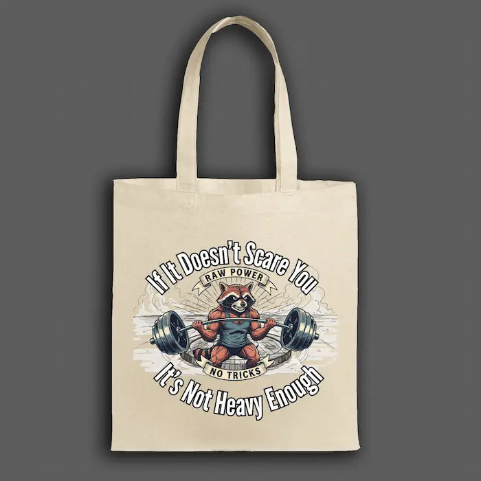 Canvas tote bag printed with “If It Doesn’t Scare You, It’s Not Heavy Enough” in bold hand-drawn typography with chalk-style texture.