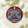 Christmas ornament with Santa Claus lifting weights and text 'Silent Night Heavy Squat' on a red background.