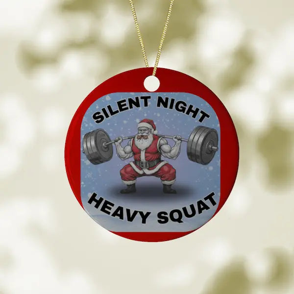 Christmas ornament with Santa Claus lifting weights and text 'Silent Night Heavy Squat' on a red background.