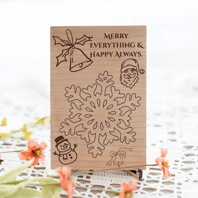 Laser-cut cherry wood postcard engraved with the phrase “Merry Everything & Happy Always,” displayed flat with festive accents.