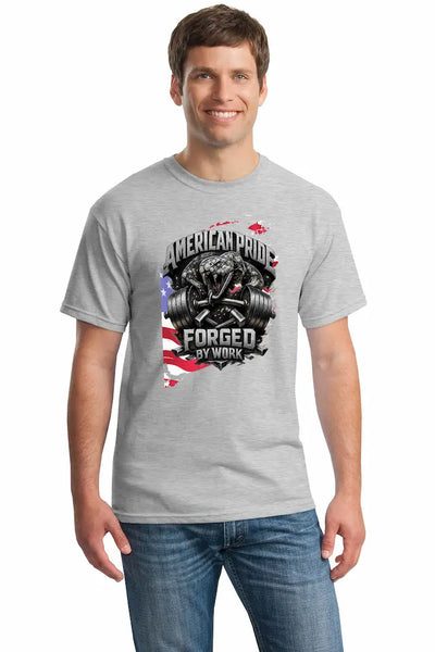 Cotton T-shirt with bold “American Pride – Forged by Work” text, modeled on a rugged workspace background.